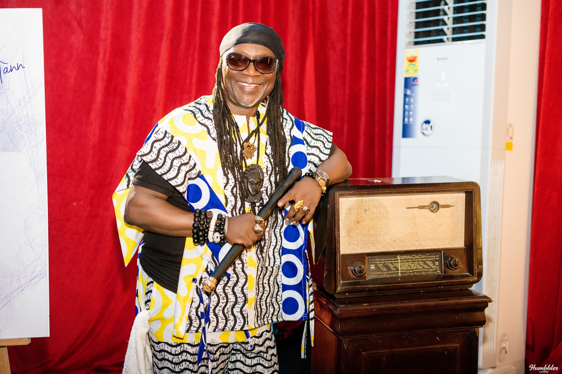 Amandzeba Nat Brew, seated beside a vintage radio