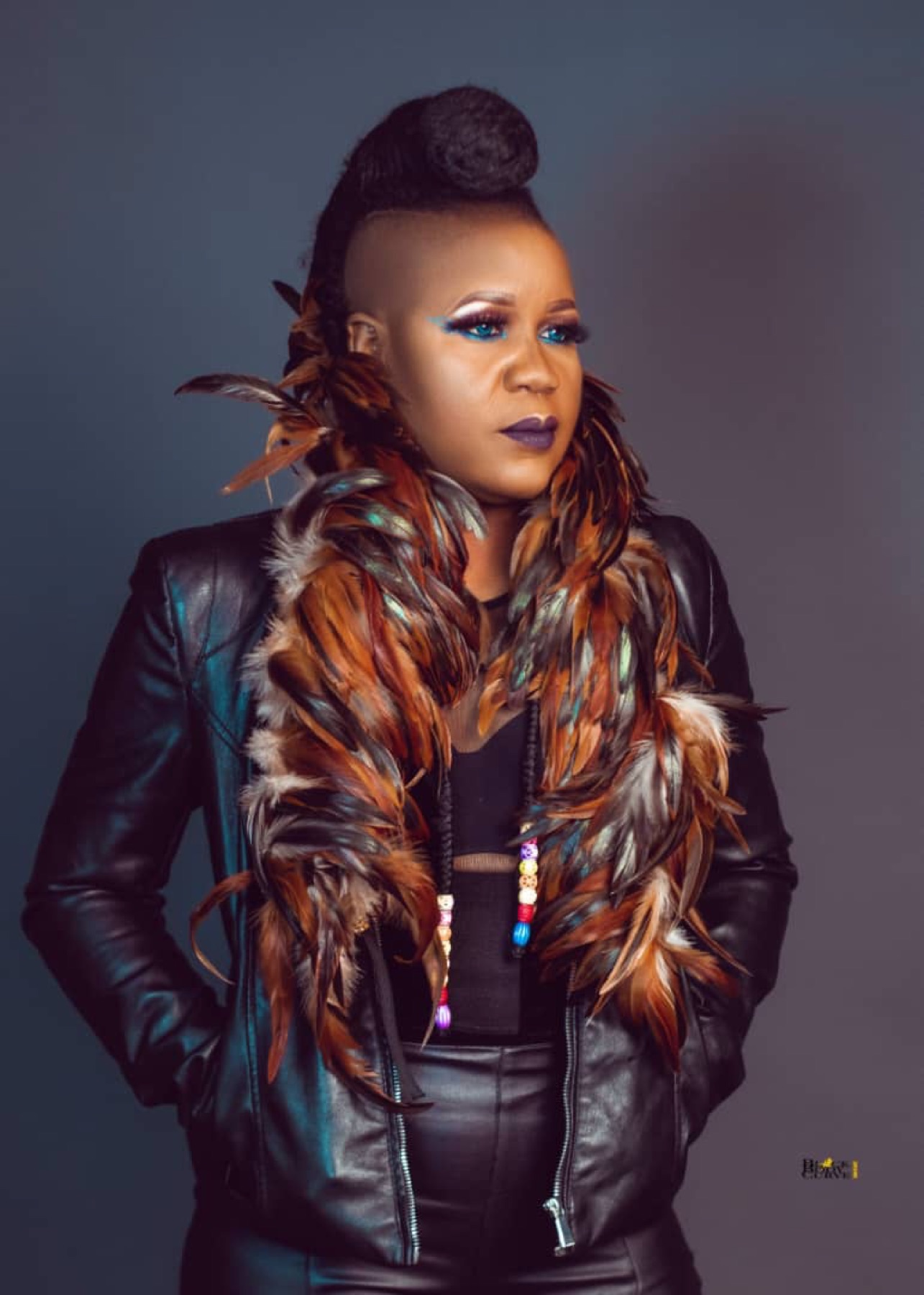 Sherifa Gunu with feathers, dark background